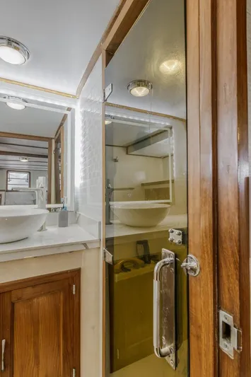 Betelgeuse Yacht Photos Pics 1988 DeFever 53 POC yacht bathroom with glass shower and wooden cabinetry.