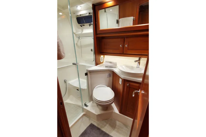 Ripple Yacht Photos Pics Luxurious bathroom in 2021 Sabre 45 Salon Express yacht with wood cabinetry and modern fixtures.