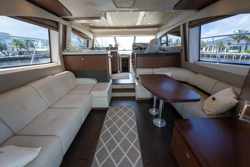 Get'er Done! Yacht Photos Pics Luxurious interior of 2016 Sea Ray 510 Fly yacht with leather seating and wooden table.