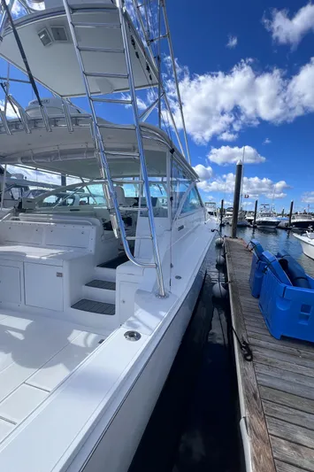 Sugar Bear Yacht Photos Pics 2001 Cabo 45 Express yacht docked under blue sky.
