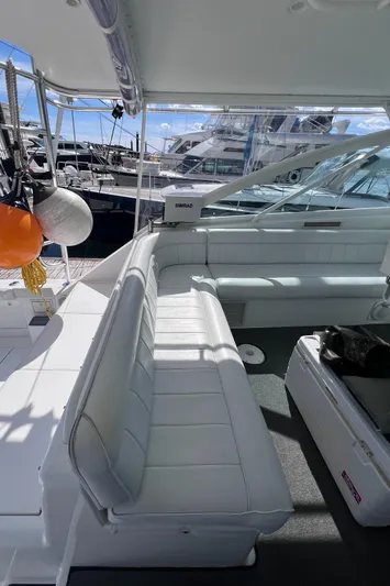 Sugar Bear Yacht Photos Pics 2001 Cabo 45 Express yacht interior with white seating and marina view.