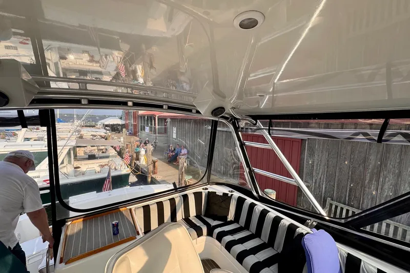 Necessity Yacht Photos Pics 2005 Albin 45 Command Bridge interior with striped seating at a marina.