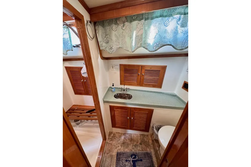 Necessity Yacht Photos Pics 2005 Albin 45 Command Bridge bathroom with wooden cabinets and nautical decor.