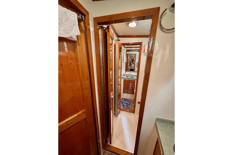 Necessity Yacht Photos Pics Narrow hallway inside 2005 Albin 45 Command Bridge yacht with wooden doors and mirror.