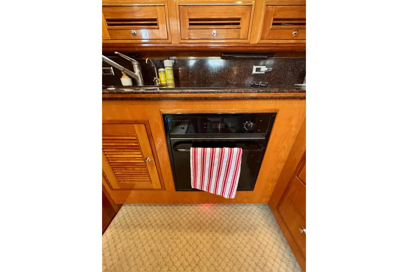 Necessity Yacht Photos Pics 2005 Albin 45 Command Bridge kitchen with wooden cabinets and striped towel.