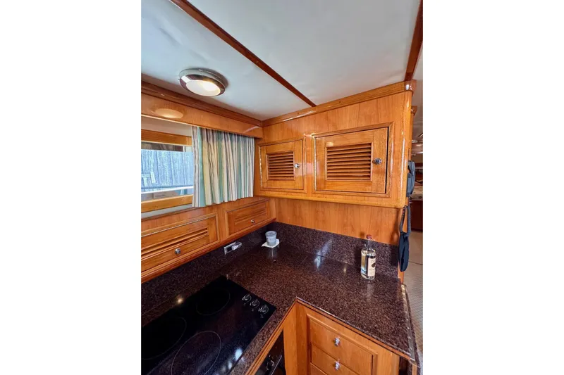 Necessity Yacht Photos Pics 2005 Albin 45 Command Bridge yacht kitchen with wooden cabinets and granite countertops.