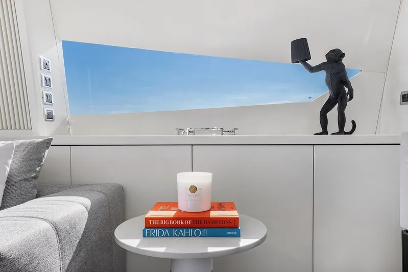 Skyfall Yacht Photos Pics Luxurious Sunseeker Predator 108 interior with books, candle, and monkey sculpture.