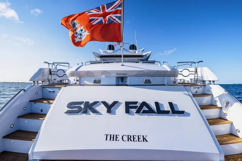 Skyfall Yacht Photos Pics 2008 Sunseeker Predator 108 yacht with flag, named "Sky Fall," docked at sea.