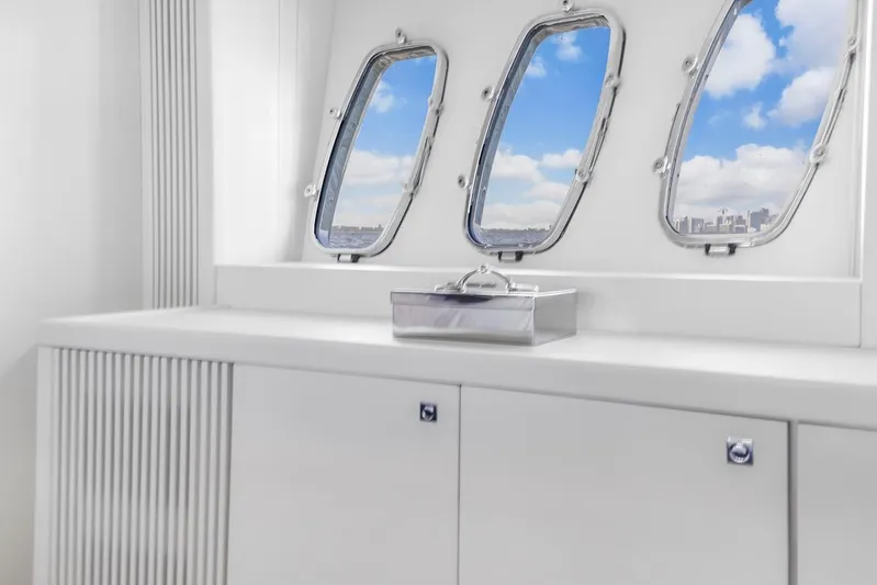 Skyfall Yacht Photos Pics Interior of 2008 Sunseeker Predator 108 yacht with porthole windows and sleek white cabinetry.