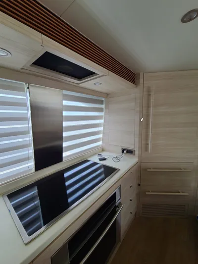  Yacht Photos Pics Modern kitchen interior in a 2017 Horizon PC60 yacht, featuring sleek appliances and wood finishes.