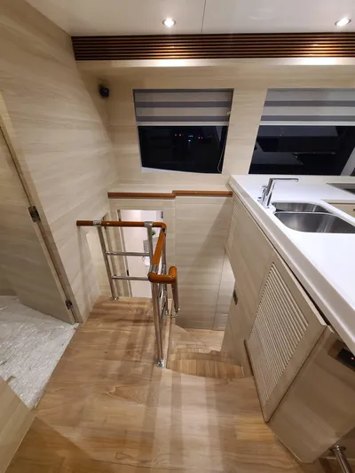  Yacht Photos Pics Modern yacht interior with wooden stairs, sleek kitchen, and large windows. Horizon PC60, 2017 model.