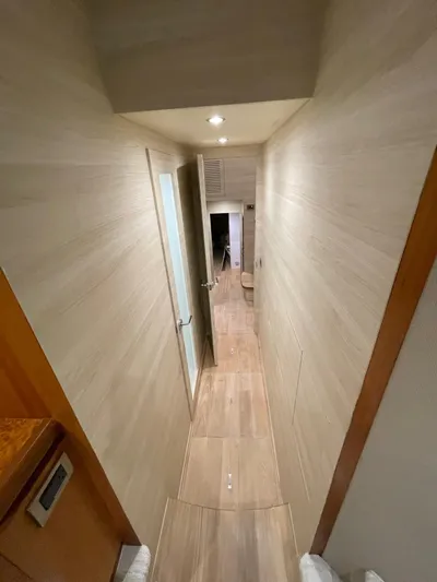  Yacht Photos Pics Narrow hallway inside 2017 Horizon PC60 yacht, featuring wooden flooring and modern lighting.