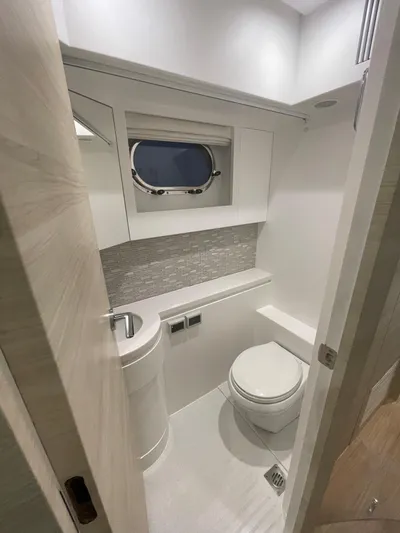  Yacht Photos Pics Modern yacht bathroom with sleek design, featuring a round sink and porthole window. Horizon PC60, 2017.