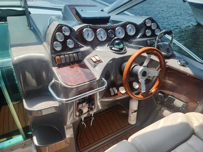 Empty Pockets Yacht Photos Pics 2006 Doral Boca Grande boat dashboard with wooden steering wheel and multiple gauges.