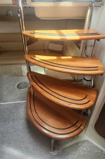 Empty Pockets Yacht Photos Pics Wooden spiral staircase inside 2006 Doral Boca Grande boat, featuring elegant curved steps.