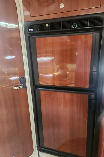 Empty Pockets Yacht Photos Pics 2006 Doral Boca Grande interior with wooden cabinetry and built-in refrigerator.