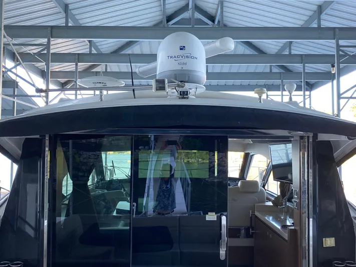  Yacht Photos Pics 2015 Sea Ray 510 Sundancer yacht with TracVision satellite, docked under a metal roof.