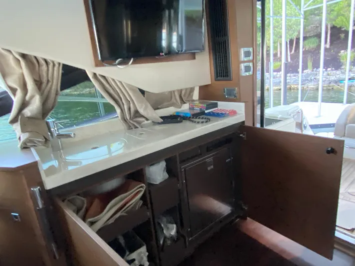  Yacht Photos Pics Interior of 2015 Sea Ray 510 Sundancer yacht with open cabinets and TV.