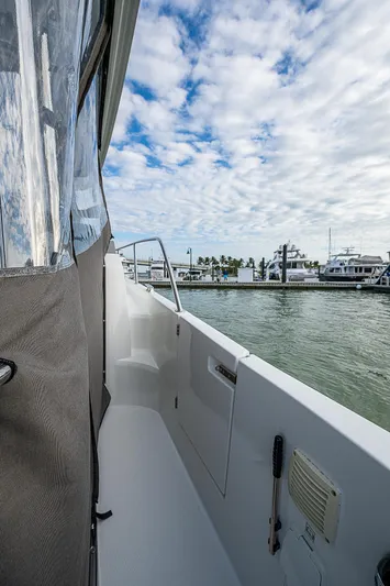 Brama Sole Yacht Photos Pics 2022 Jeanneau Leader 12.5 boat docked, side view with cloudy sky and marina background.
