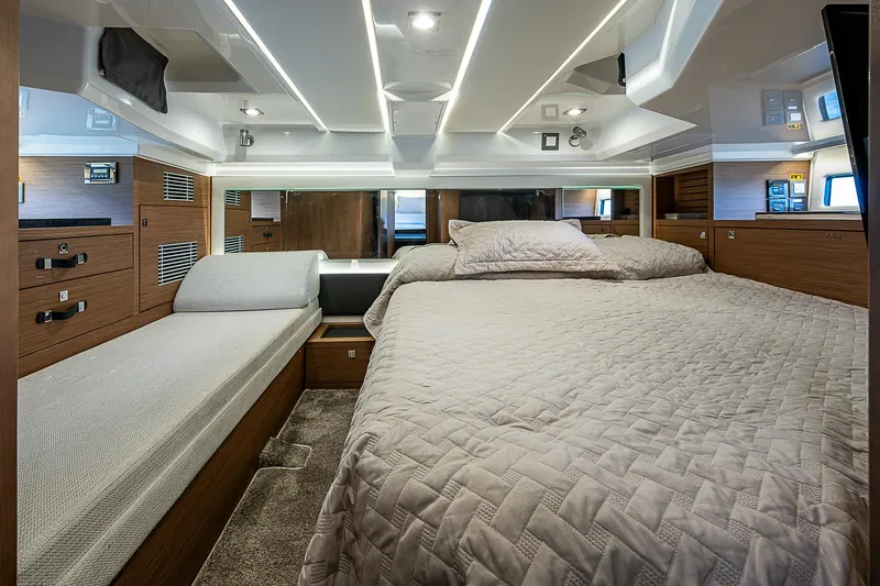 Brama Sole Yacht Photos Pics 2022 Jeanneau Leader 12.5 cabin interior with modern bedding and wood accents.