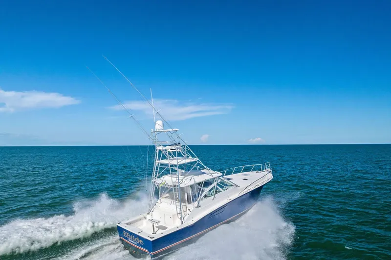 Ebtide Yacht Photos Pics 2006 Cabo 45 Express yacht cruising on open ocean under clear blue sky.