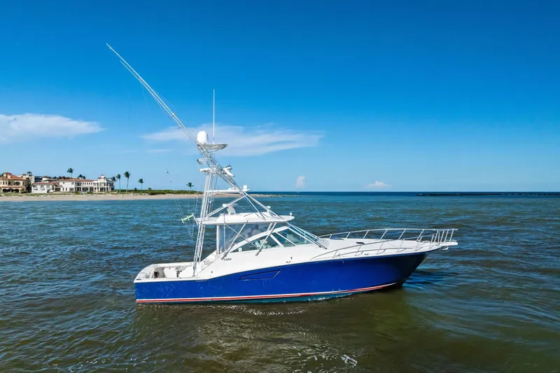 Ebtide Yacht Photos Pics 2006 Cabo 45 Express boat on calm waters with clear blue sky.