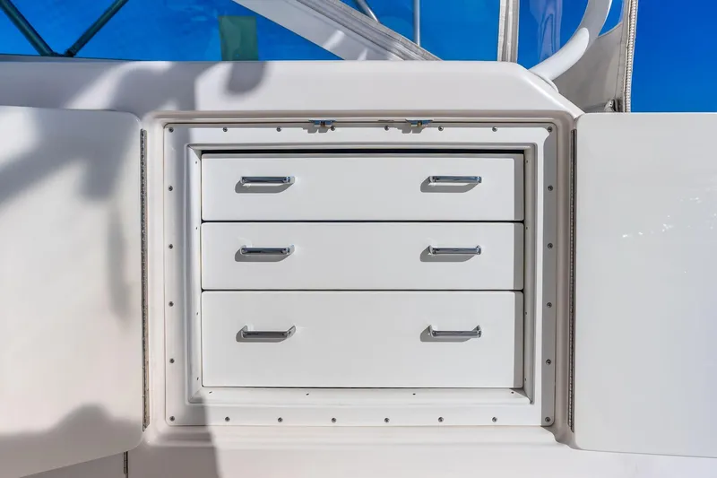 Ebtide Yacht Photos Pics White storage drawers on a 2006 Cabo 45 Express boat, set against a blue sky.