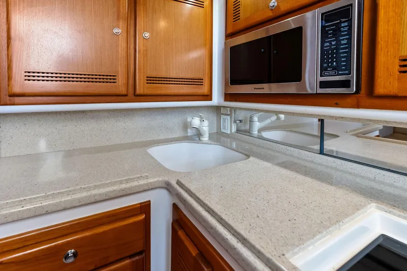 Ebtide Yacht Photos Pics 2006 Cabo 45 Express yacht kitchen with wooden cabinets and modern appliances.