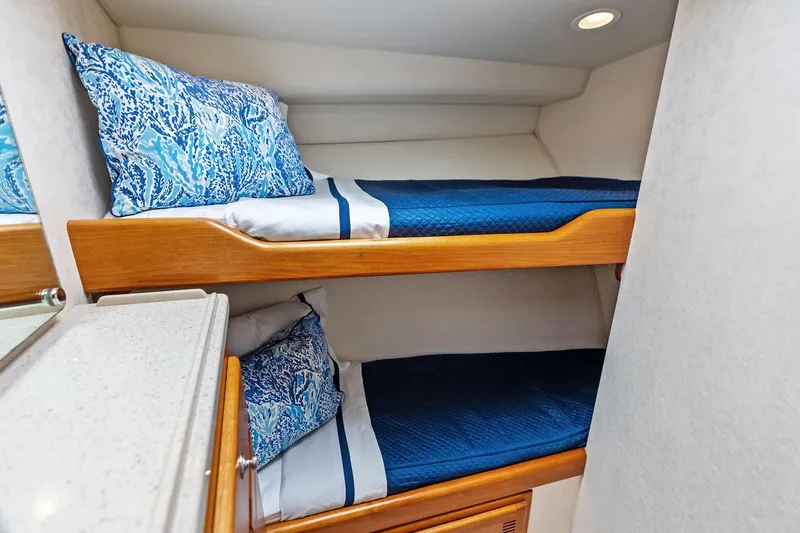 Ebtide Yacht Photos Pics 2006 Cabo 45 Express yacht interior with cozy bunk beds and blue bedding.