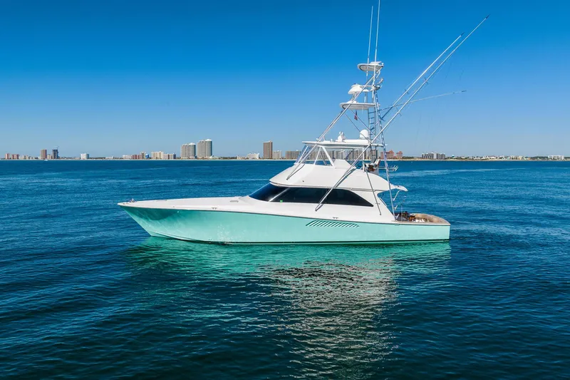 Unleashed Yacht Photos Pics 2007 Viking 56 Convertible yacht on calm blue ocean with city skyline background.