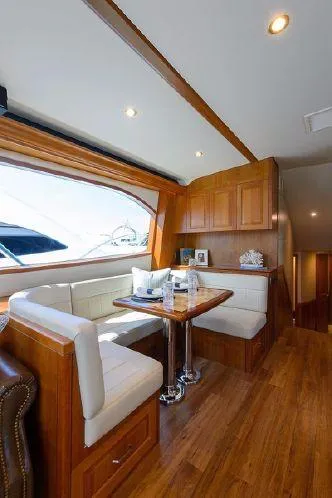 Sixpack Yacht Photos Pics Interior of 2013 Hatteras GT63 yacht with elegant wood finish and cozy dining area.