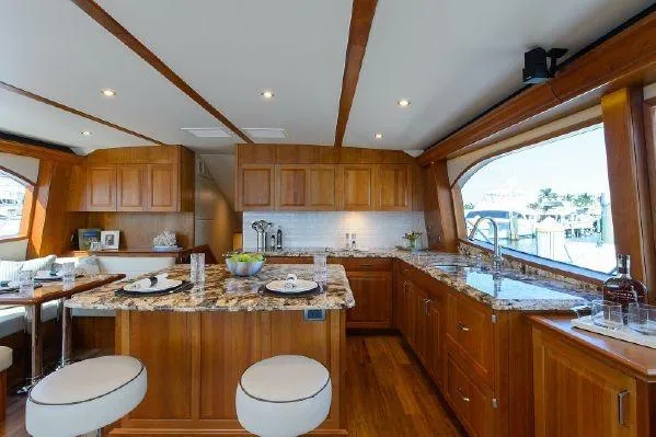 Sixpack Yacht Photos Pics Luxurious interior of 2013 Hatteras GT63 yacht with elegant wooden cabinetry and granite countertops.