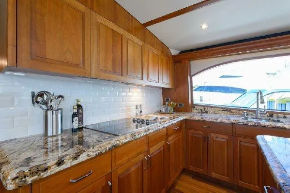 Sixpack Yacht Photos Pics Luxurious kitchen interior of 2013 Hatteras GT63 yacht with wooden cabinets and granite countertops.