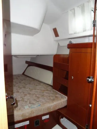 Royce Yacht Photos Pics Interior cabin of 2007 Beneteau 423 sailboat with wooden furnishings and cozy bed.