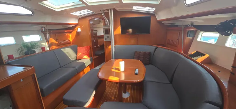 Royce Yacht Photos Pics Interior of 2007 Beneteau 423 yacht with cozy seating, table, and TV.