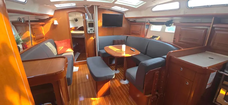 Royce Yacht Photos Pics Interior of a 2007 Beneteau 423 sailboat with elegant wood finish and cozy seating area.