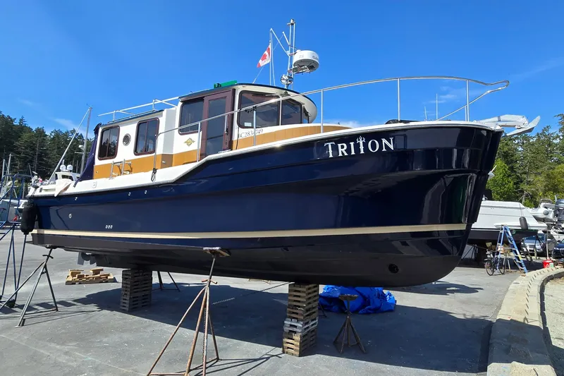 Triton Yacht Photos Pics 2011 Ranger Tugs R-29 boat named Triton on dry dock under clear blue sky.