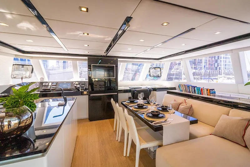 Deo Juvante Yacht Photos Pics Luxurious interior of 2018 Sunreef 62 ARC yacht with elegant dining area and modern decor.