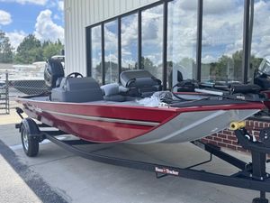 2025 Tracker Bass Tracker Classic XL boat in red, parked on a trailer outside a building.