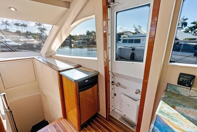 Satellite Office Yacht Photos Pics Interior view of 2008 Hatteras 64 Motor Yacht with elegant wood finishes and marina view.