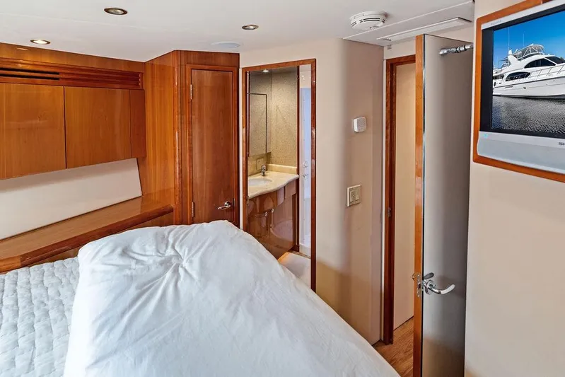 Satellite Office Yacht Photos Pics Interior of 2008 Hatteras 64 Motor Yacht bedroom with ensuite bathroom and TV.