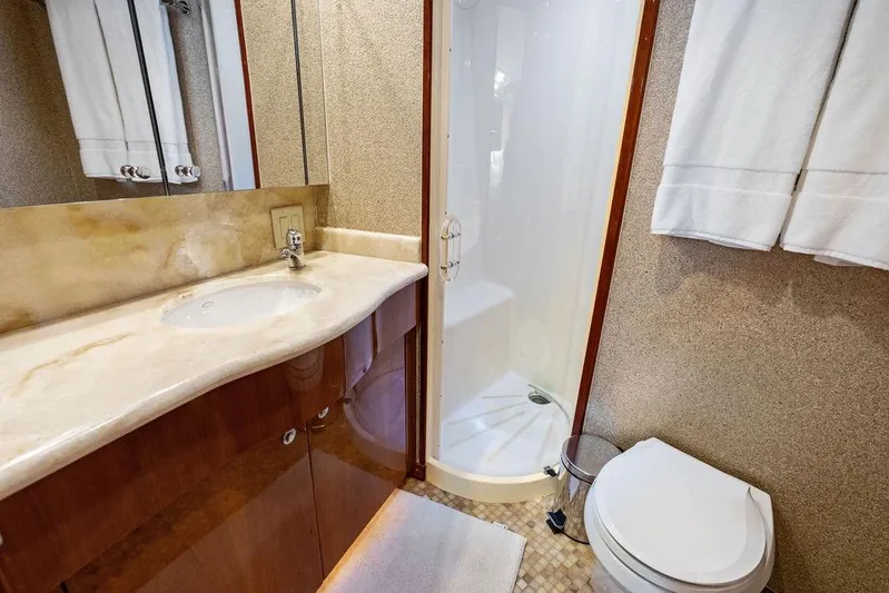 Satellite Office Yacht Photos Pics Luxurious bathroom in 2008 Hatteras 64 Motor Yacht with shower, sink, and toilet.
