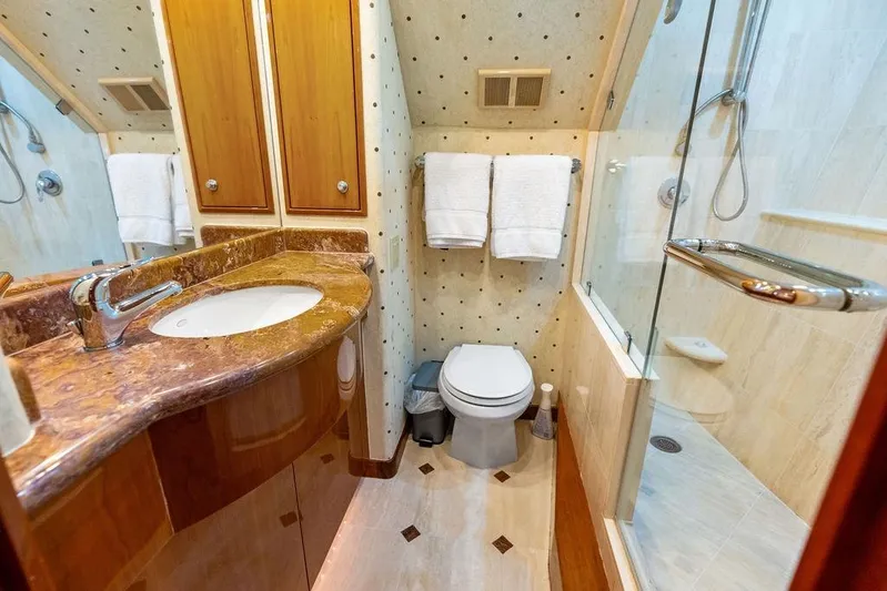 Satellite Office Yacht Photos Pics Luxurious bathroom in 2008 Hatteras 64 Motor Yacht with marble countertop and glass shower.