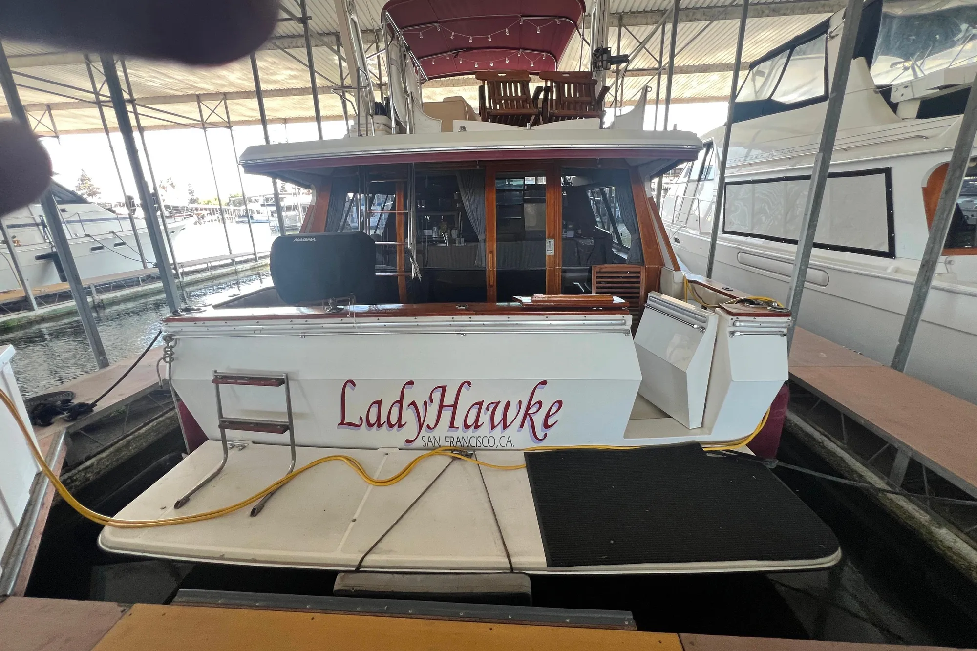 1986 Bayliner 4550 Motoryacht "LadyHawke" docked in marina, rear view.