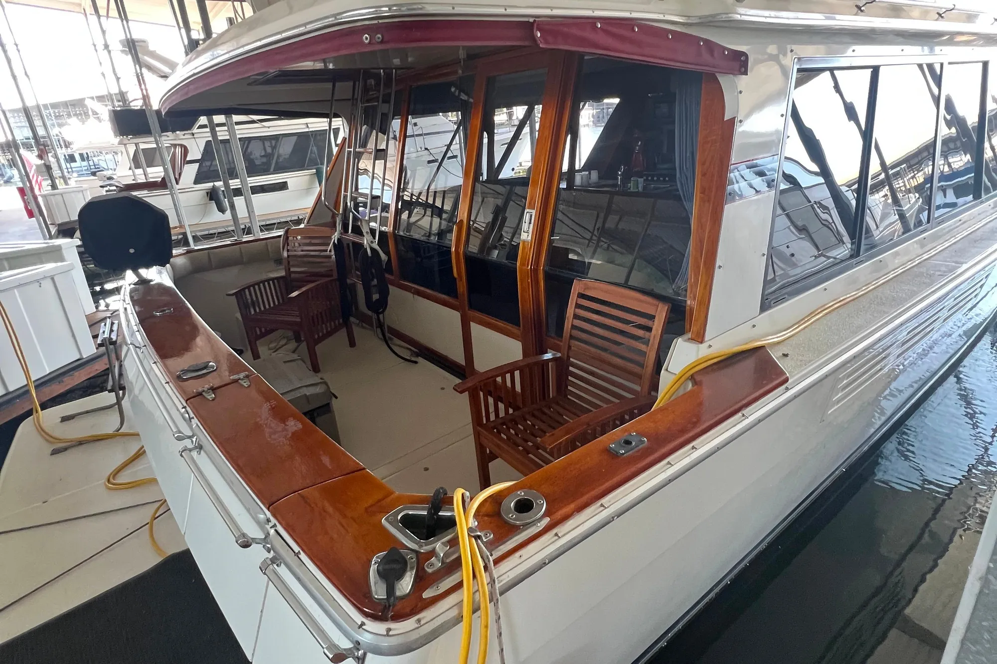 1986 Bayliner 4550 Motoryacht with wooden deck chairs and polished wood accents in marina.