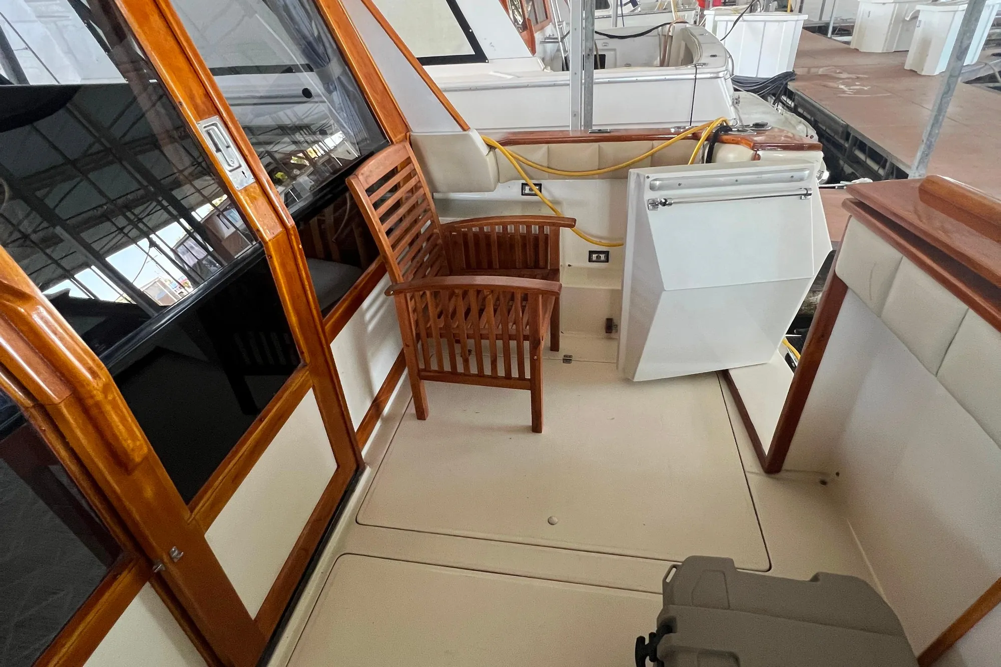 1986 Bayliner 4550 Motoryacht deck with wooden chair and storage compartment.