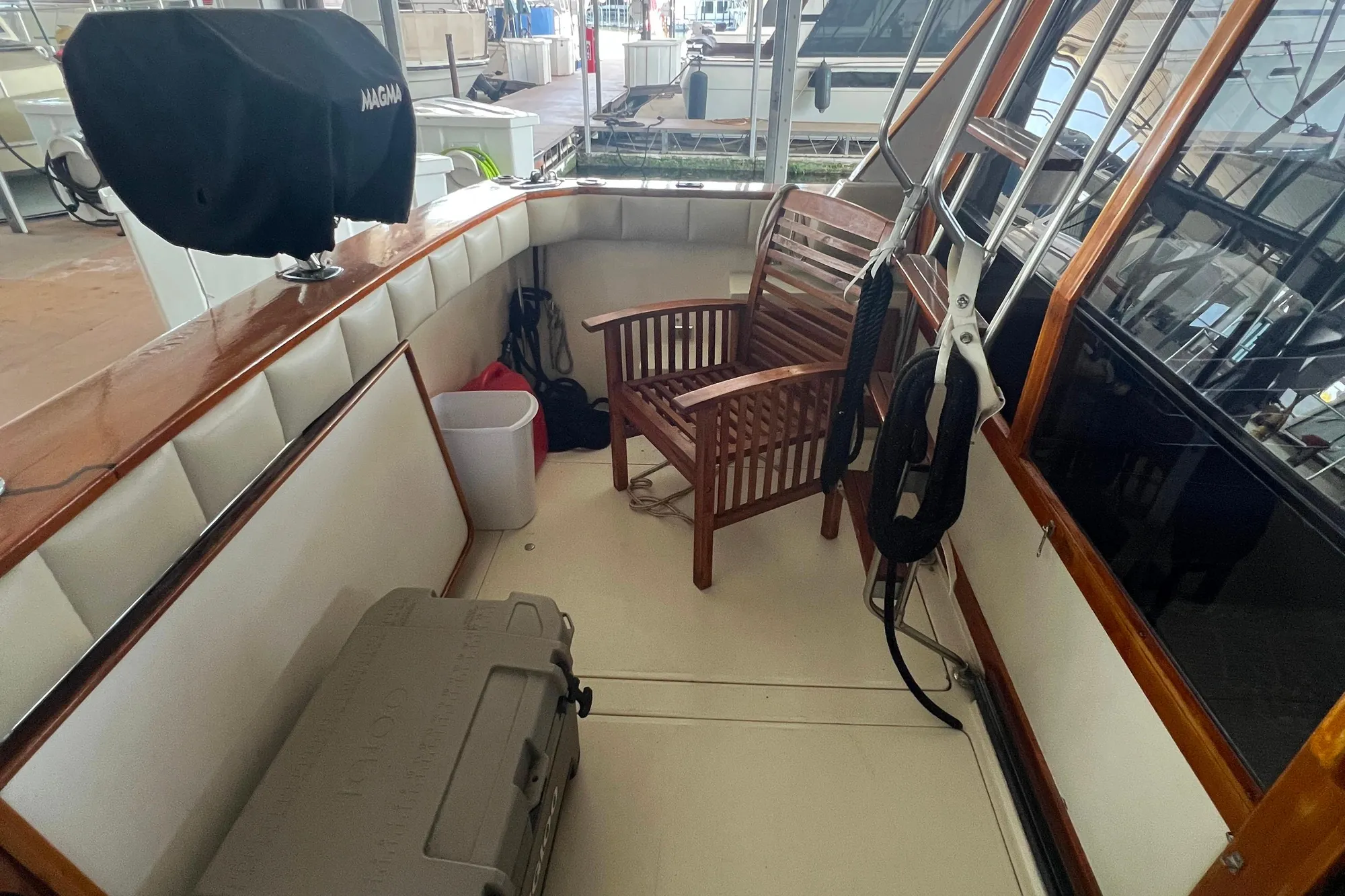 1986 Bayliner 4550 Motoryacht deck with wooden chair, cooler, and grill.