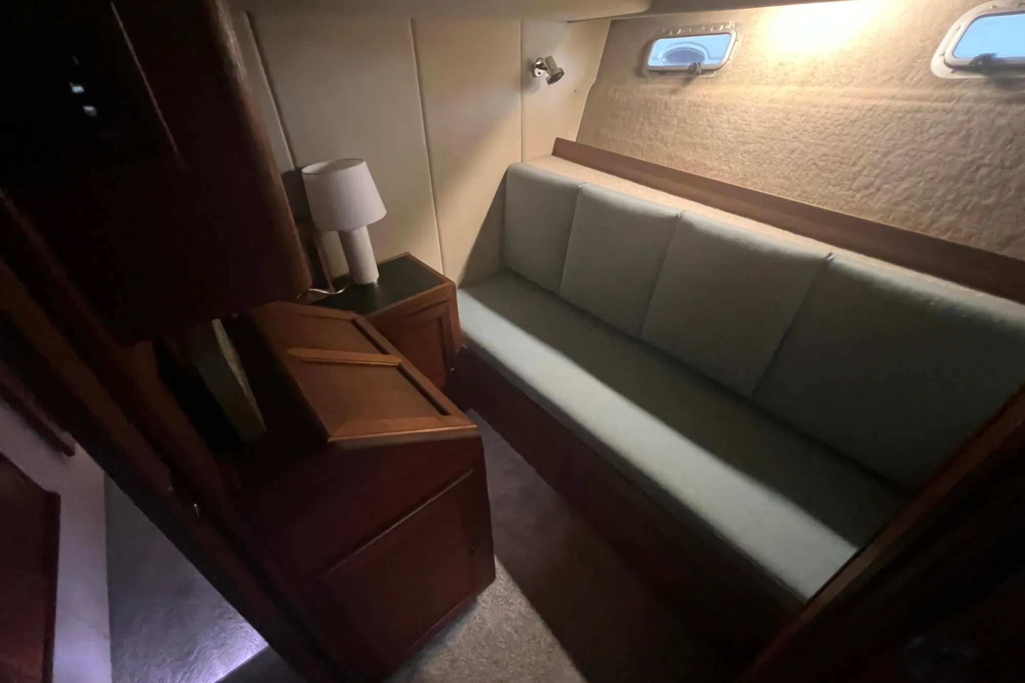 Interior of 1986 Bayliner 4550 Motoryacht with sofa, lamp, and porthole windows.