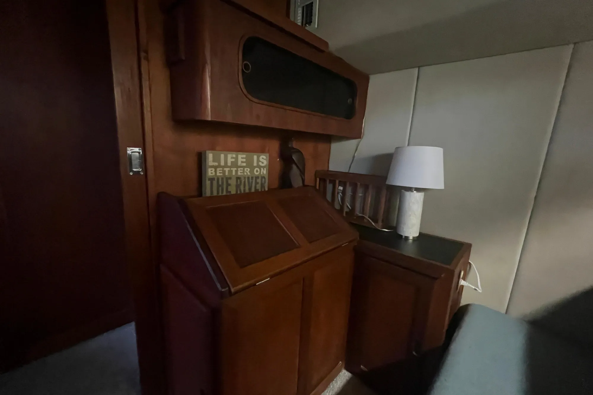 Interior of 1986 Bayliner 4550 Motoryacht with wooden cabinetry and lamp.