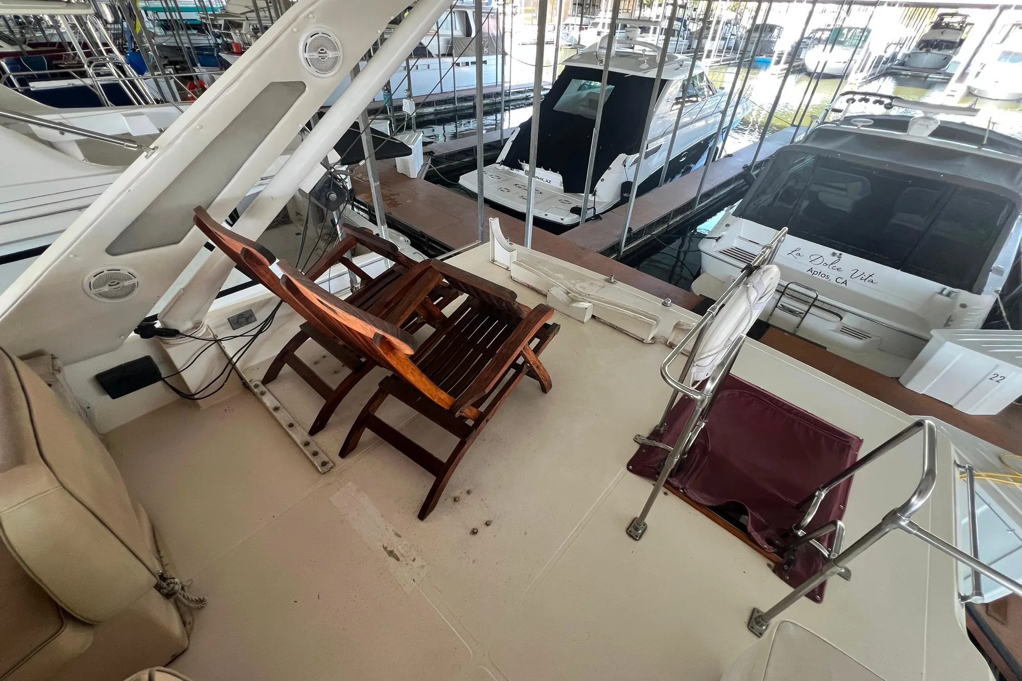 1986 Bayliner 4550 Motoryacht deck with wooden chair and marina view.